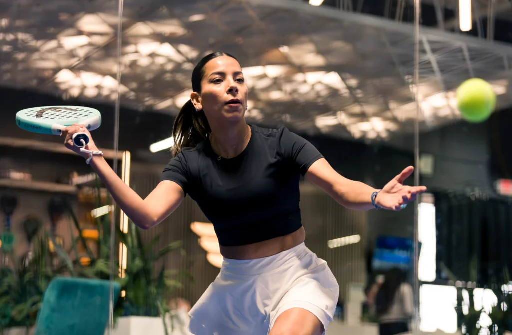 Padel player hitting a ball during the indoor league season.